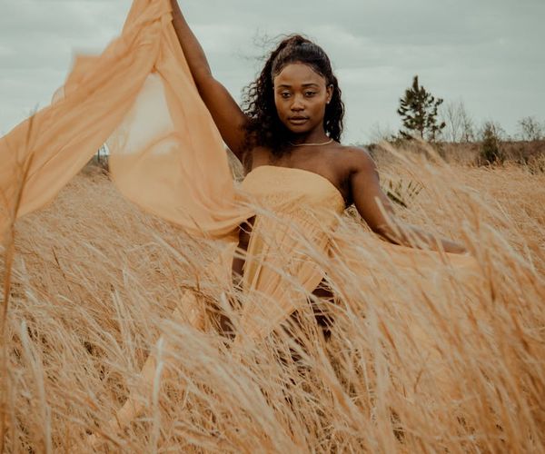 Woman in a calm, flowing pose against a light blue background.